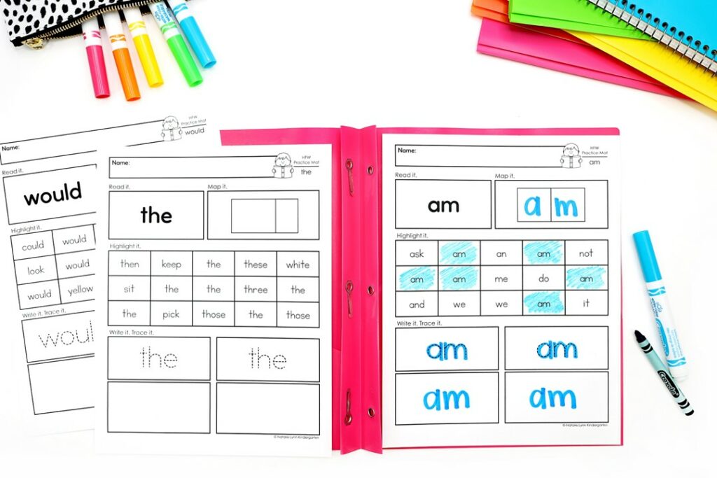 heart words and high frequency words worksheets science of reading - image shows multiple worksheets sitting on a red folder. The worksheet for the word am is filled out.