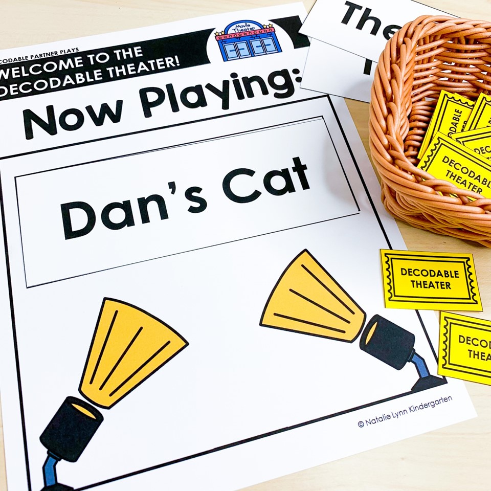 Decodable partner plays reader theater materials including theater sign that says "Welcome to the Decodable Theater. Now Playing: Dan's Cat" and tickets in a basket.