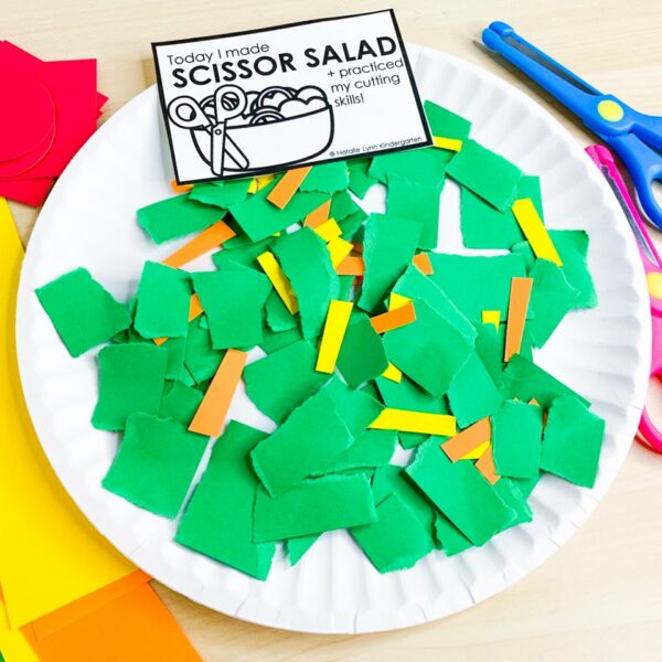 scissor salad cutting practice activity for preschool, pre-k, or kindergarten | image shows a paper plate with torn green paper and cut shreds of orange and yellow paper