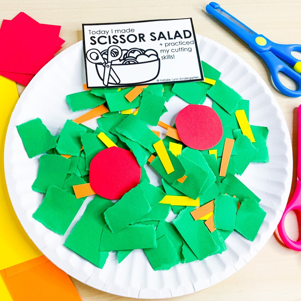 scissor salad cutting practice activity for preschool, pre-k, or kindergarten | image shows a paper plate with torn green paper and cut shreds of orange and yellow paper and red circles