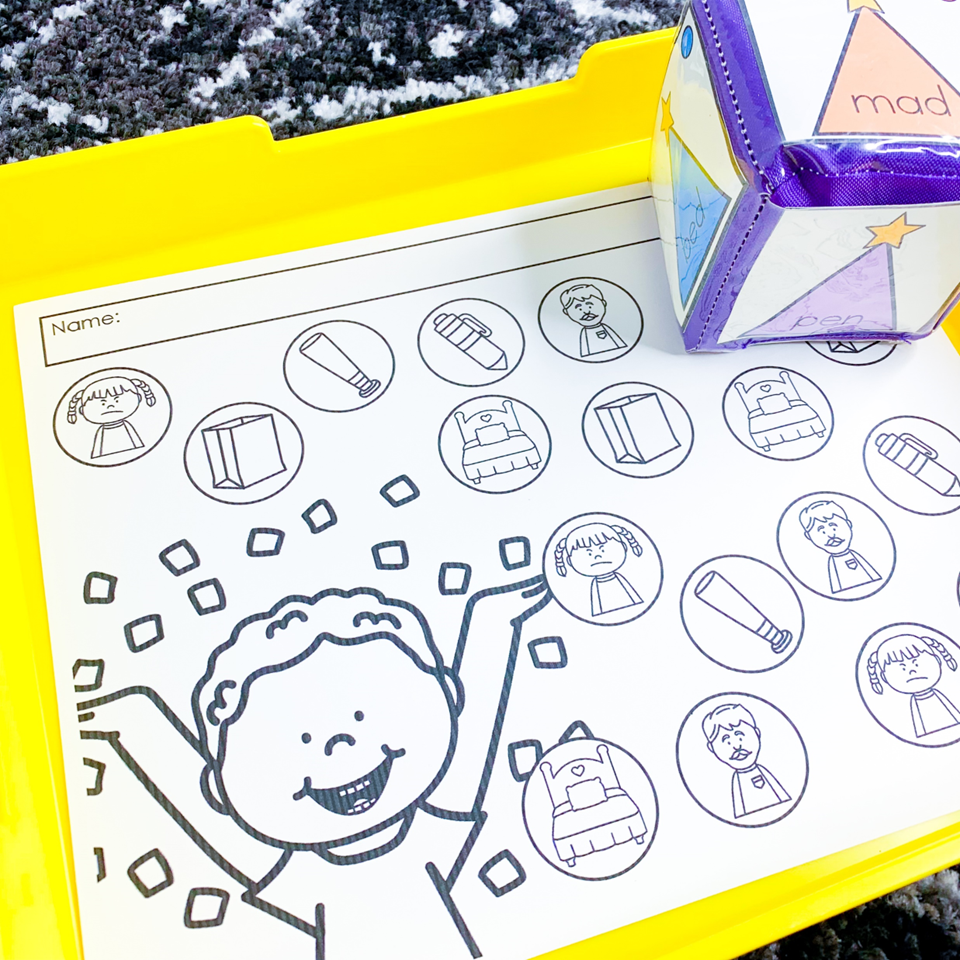 Kindergarten New Year's Eve centers | image shows a pocket dice with party hats and a recording sheet with pictures of CVC words on a yellow tray