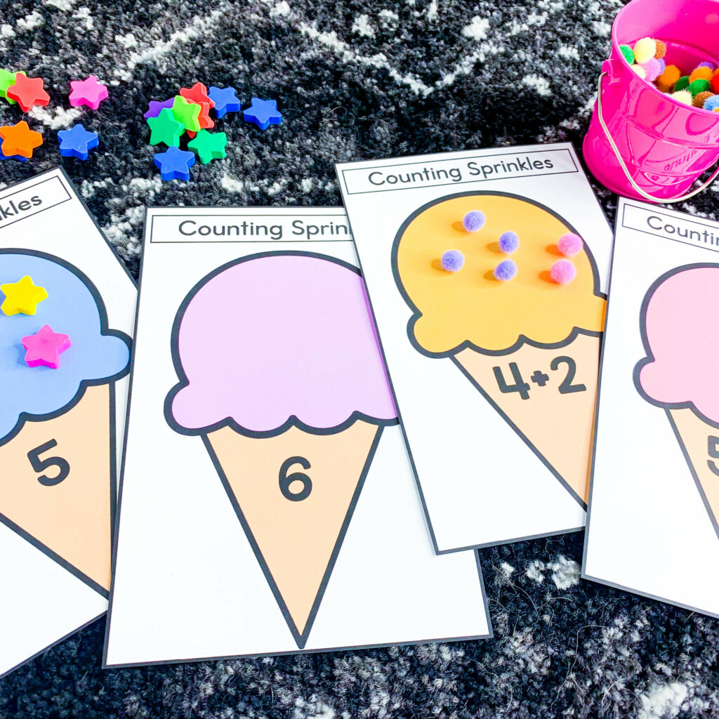 free end of the year ice cream theme days for kindergarten and first grade | image shows printed ice cream cones with numbers and addition equations on them laying on a black and white carpet background.