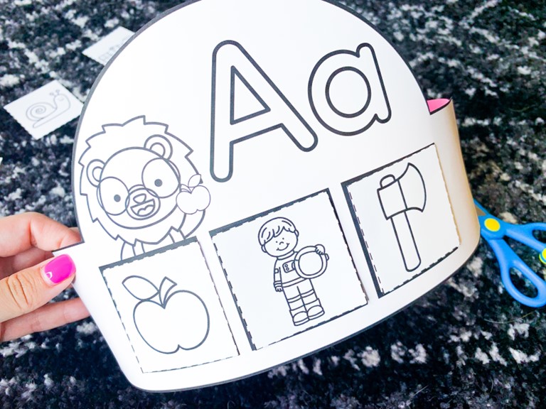 alphabet hats and crowns free download | image shows an alphabet crown for the letter Aa with Letter Lion holding an apple and three pictures of an apple, an astronaut, and an axe